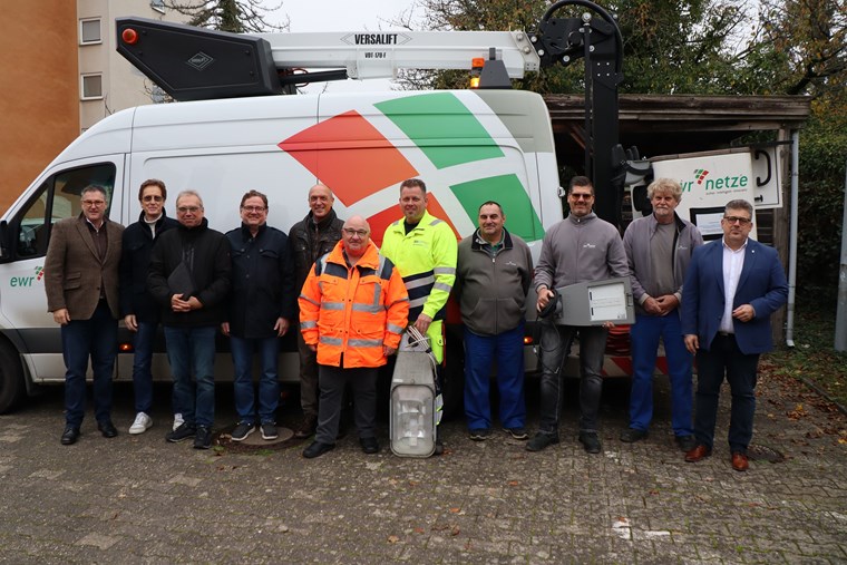 Verantwortliche und Monteure beim Gruppenbild mit den alten (links) und neuen Leuchtenköpfen