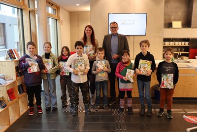 Oberbürgermeister Thomas Feser und Büchereileiterin Julia Löffler bei der Gewinnübergabe an die glücklichen Kinder