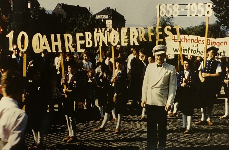 Eine Gruppe des Winzerzuges trägt die Buchstaben "1858 - 1958 100 Jahre Winzerfest"