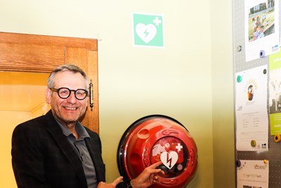 Oberbürgermeister Thomas Feser vor dem Defibrillator auf Burg Klopp.